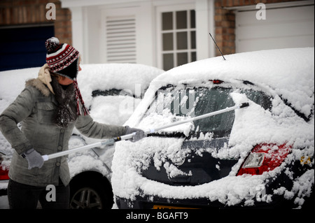 Femme balaie la neige sur sa voiture Brighton UK hiver météo Banque D'Images