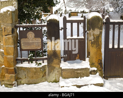 Neige sur une porte à l'entrée de l'église All Saints sur la Piste du patrimoine du capitaine James Cook Grand Ayton North Yorkshire Banque D'Images