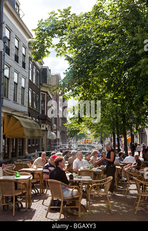 Des gens assis dans un bar à l'extérieur de l'ancien centre ville de Delft, Pays-Bas Banque D'Images