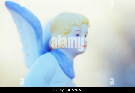 Close up impressionniste dans la lumière froide de l'ange d'un enfant en robe blanche et bleue avec des cheveux d'or des yeux bleus et des lèvres rouge Banque D'Images