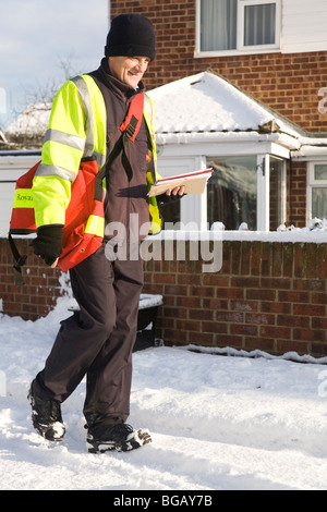 Un facteur fait ses livraisons de Noël malgré la neige qui a affecté l'état des routes dans le nord de l'Angleterre. Banque D'Images