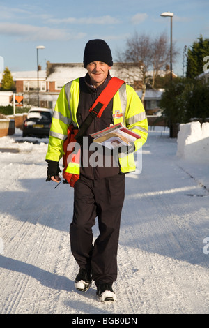 Un facteur fait ses livraisons de Noël malgré la neige qui a affecté l'état des routes dans le nord de l'Angleterre. Banque D'Images