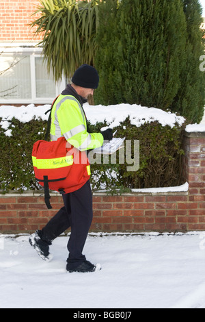 Un facteur fait ses livraisons de Noël malgré la neige qui a affecté l'état des routes dans le nord de l'Angleterre. Banque D'Images