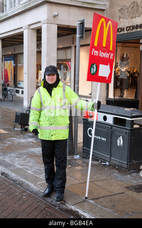 Un homme avec une affiche publicité McDonalds, Cambridge UK Banque D'Images