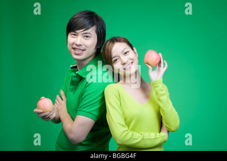 Couple en vert sur fond vert avec des pommes Banque D'Images