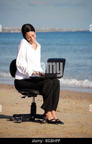 Office worker working on beach Banque D'Images