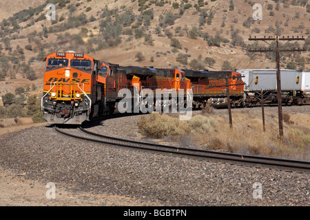 Un train de marchandises de BNSF dirigé par GE construit ES44DC 7405 Locomotive gravit la pente est près de la boucle de Tehachapi. Banque D'Images