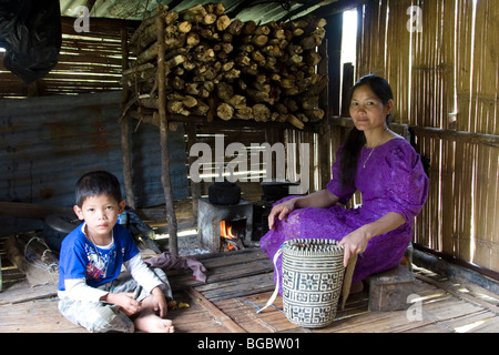 Un Penan la mère et le fils dans leur maison, une petite cabane construite de bois et de bambou et les rebuts de Bornéo en Malaisie. Banque D'Images
