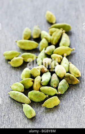 Plusieurs des gousses de cardamome verte entière sur fond de bois Banque D'Images