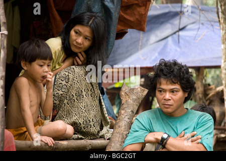 Une famille Penan en dehors de leur hutte de fortune dans le Bario Kelabit Highlands au Sarawak à Bornéo. Banque D'Images