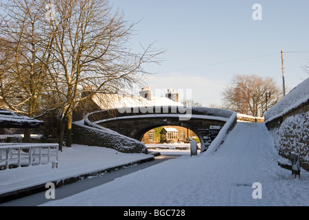 View of bridge au pic de blocage supérieur canal forêt marple dans la neige Banque D'Images