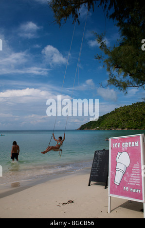 Dame balançant sur une balançoire sur la plage de Haad Salad à Koh Phangan, Thaïlande Banque D'Images