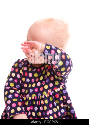 1 ans petite fille blonde lui couvre le visage isolated on white Banque D'Images