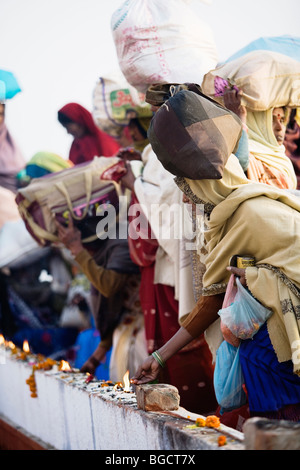 Pèlerins hindous bougies d'éclairage sur les ghats, la rivière escaliers de Varanasi, en Inde. Banque D'Images