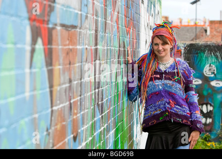 Jeune femme avec des cheveux de couleur hippie contre mur de graffiti. Modèle entièrement libéré Banque D'Images