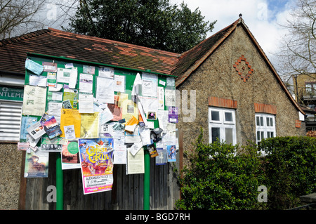 Tableau d'affichage communautaire en face des wc publics de la place de l'étang du village de Highgate London England UK Banque D'Images