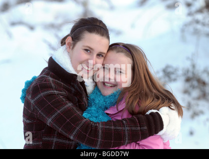 Soeurs heureusement hugging out par temps froid Banque D'Images