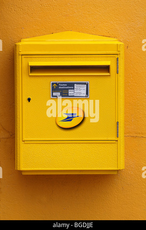 Post box français jaune sur un mur jaune, Riedwihr, Alsace, France, Europe Banque D'Images