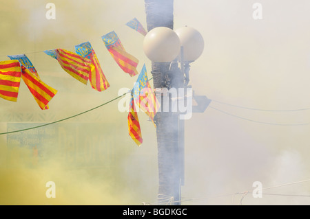 Drapeaux et fumée dans 'La Mascletà' (d'artifice). 'Les Falles' (en valencien) aka "Las Fallas" (en espagnol). Valence. Espagne Banque D'Images