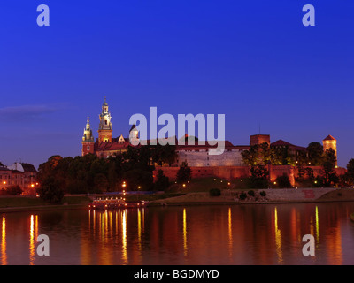 Château Royal de Wawel illuminé de nuit qui reflète de la Vistule, Cracovie - Pologne Banque D'Images