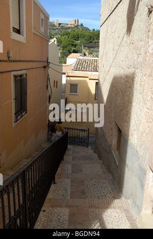 Woman walking down steps de rue étroite dans le village de montagne de Relleu, Province d'Alicante, Communauté Valencienne, Espagne Banque D'Images