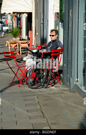 Homme assis à l'extérieur de Café Upper street bike avec pli jusqu'à Islington Londres Angleterre Royaume-uni Banque D'Images