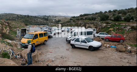 Les voitures palestiniennes attendent des passagers dans une route menant à un village palestinien bloqué par l'armée israélienne près de la ville juive de Modiin, Israël Banque D'Images