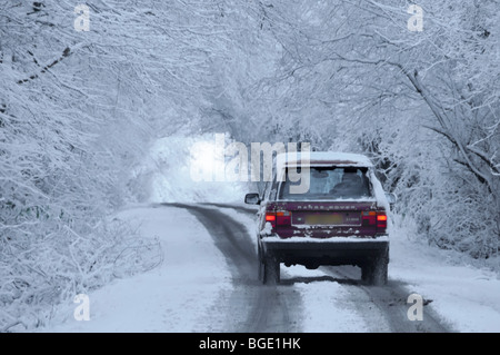 Scène de neige arrière vue arrière Range Rover voiture conduisant la route de campagne sous le tunnel d'arbres couverts de neige dans les merveilles d'hiver Brentwood Essex Angleterre Royaume-Uni Banque D'Images