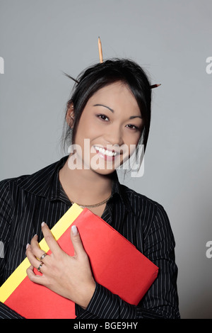Les jeunes femmes mignon drôle expressif asiatique femme qui travaille au bureau Banque D'Images