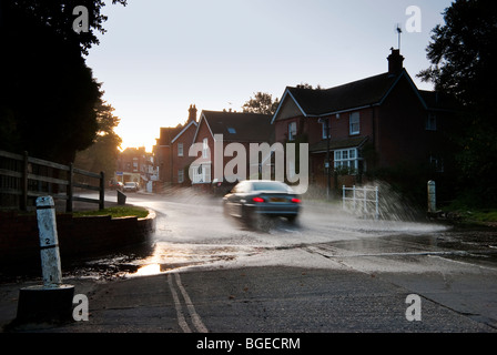 Voiture roulant à travers le watersplash à Brockenhurst, dans la nouvelle forêt tôt le matin Banque D'Images