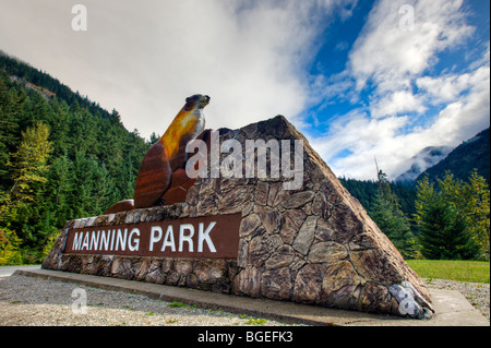 Signer avec une sculpture d'un castor à l'entrée de Manning Park (E C Le parc provincial Manning), British Columbia, Canada. Banque D'Images