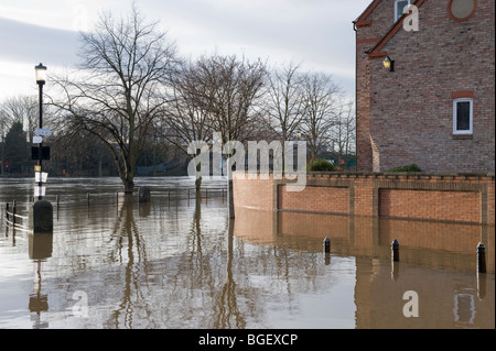 La rivière Ouse a éclaté sur ses rives après une forte pluie (sentier au bord de la rivière submergé par les eaux inondées, barrière murale de maison haute) - York, North Yorkshire, Angleterre. Banque D'Images