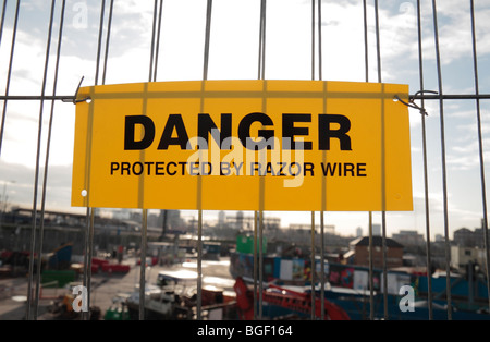 Un "danger protégées par des barbelés' signe sur le bord du site de construction des Jeux Olympiques de 2012, Stratford, au Royaume-Uni. Banque D'Images