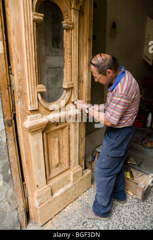 Groupe de travail sur le rétablissement de l'homme polonais une vieille porte en bois, sur une propriété dans le centre-ville de Cracovie. La Pologne. Banque D'Images