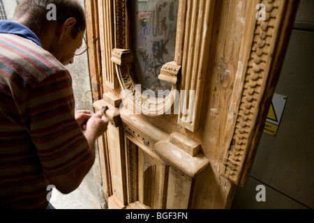 Groupe de travail sur le rétablissement de l'homme polonais une vieille porte en bois, sur une propriété dans le centre-ville de Cracovie. La Pologne. Banque D'Images