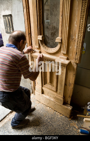 Groupe de travail sur le rétablissement de l'homme polonais une vieille porte en bois, sur une propriété dans le centre-ville de Cracovie. La Pologne. Banque D'Images