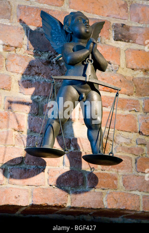 Putto ailé en laiton, avec une balance, sur un mur au château de Wawel. Cracovie, Pologne. Banque D'Images