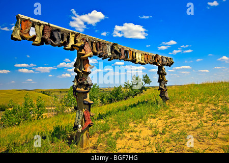 Bottes de cow-boy de raccrocher sur un châssis à l'entrée du Great Sand Hills près de Sceptre, Saskatchewan, Canada. Banque D'Images