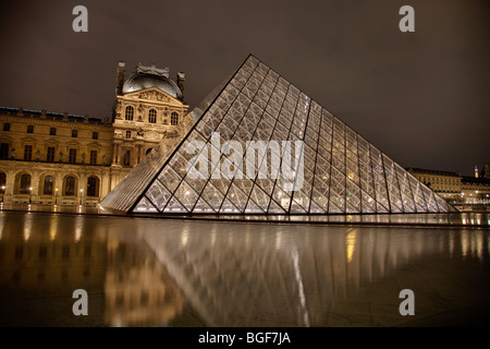 Pyramide du Louvre et Triangle éclairés la nuit avec la Tour Eiffel en arrière-plan Banque D'Images