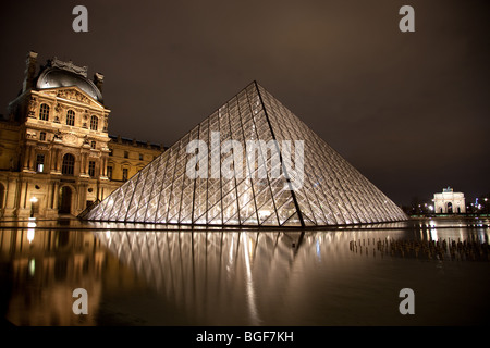 Pyramide du Louvre et Triangle éclairés la nuit avec Carousel en arrière-plan Banque D'Images