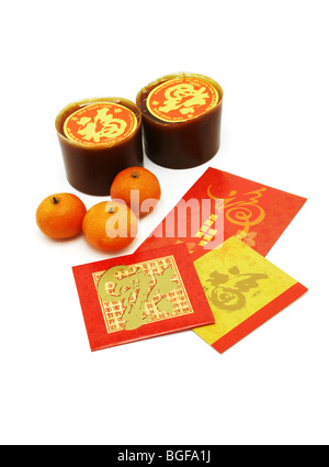 Le Nouvel An chinois gâteaux de riz, les oranges et les paquets rouges disposées sur fond blanc Banque D'Images
