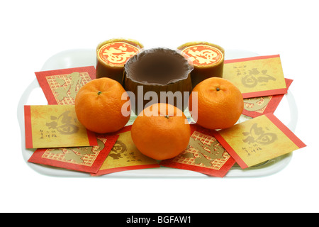 Le Nouvel An chinois gâteaux de riz, les oranges et rouges les paquets sur un plateau de service Banque D'Images