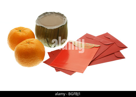 Gâteau du Nouvel An chinois, les oranges et les paquets rouge sur fond blanc Banque D'Images