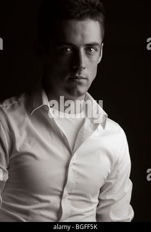 Touche bas noir et blanc Portrait of a Handsome vingtaine mâle en chemise blanche Banque D'Images