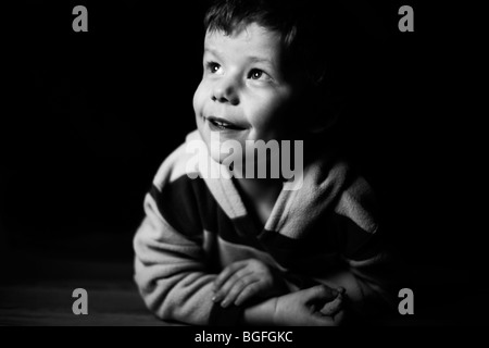 Photo en noir et blanc d'un garçonnet de cinq ans dans l'Éclairage dramatique Banque D'Images
