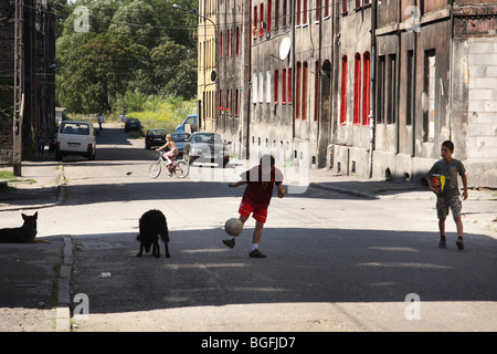 Les enfants jouent au football sur la vieille rue. Lipiny district, Swietochlowice, Haute Silésie, Pologne. Banque D'Images