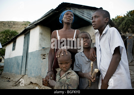 Une famille touchée par la tuberculose à l'extérieur de leur maison à Gonaïves, Haïti, Département de l'Artibonite Banque D'Images