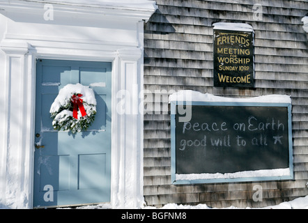 Evergreen christmas wreath with red bow couverte de neige fraîche sur la porte d'un bois d'une maison de réunion,Cape Cod, USA. Banque D'Images