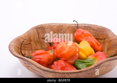 Piments Scotch Bonnet Caraïbes mixtes dans bol en bois contre fond blanc Banque D'Images