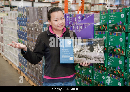 Mid adult woman shopping holiday lights LED économe en énergie chez Costco. San Francisco, California, USA Banque D'Images